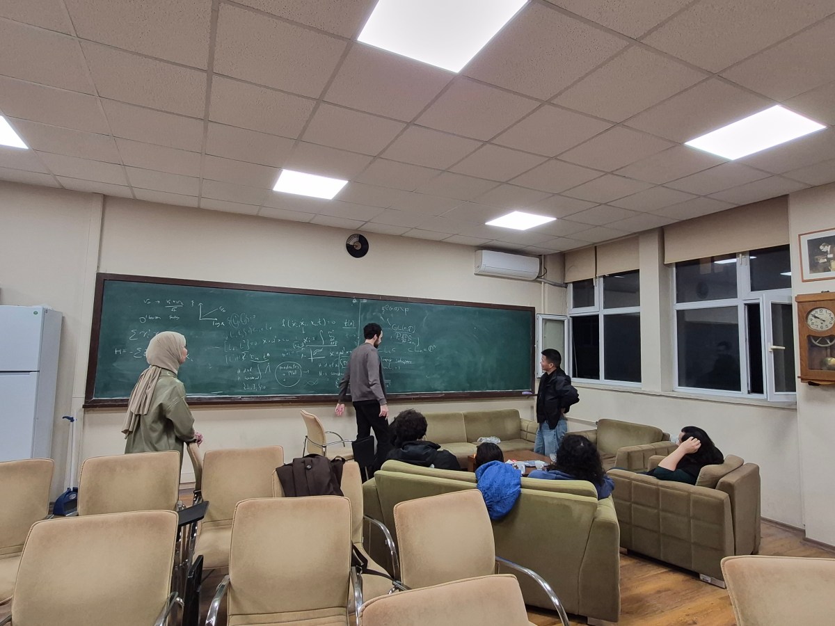 Participants discussing calculations at a blackboard during Istanbul Stringy Meeting 2026